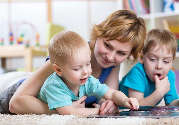 Image of a mother and children reading on the carpet after taking advantage of fast carpet cleaning in West Valley City